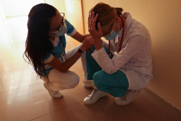 image of nurse with stressed out doctor during pandemic 